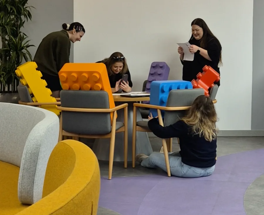 The team working around a table with oversized toy bricks
